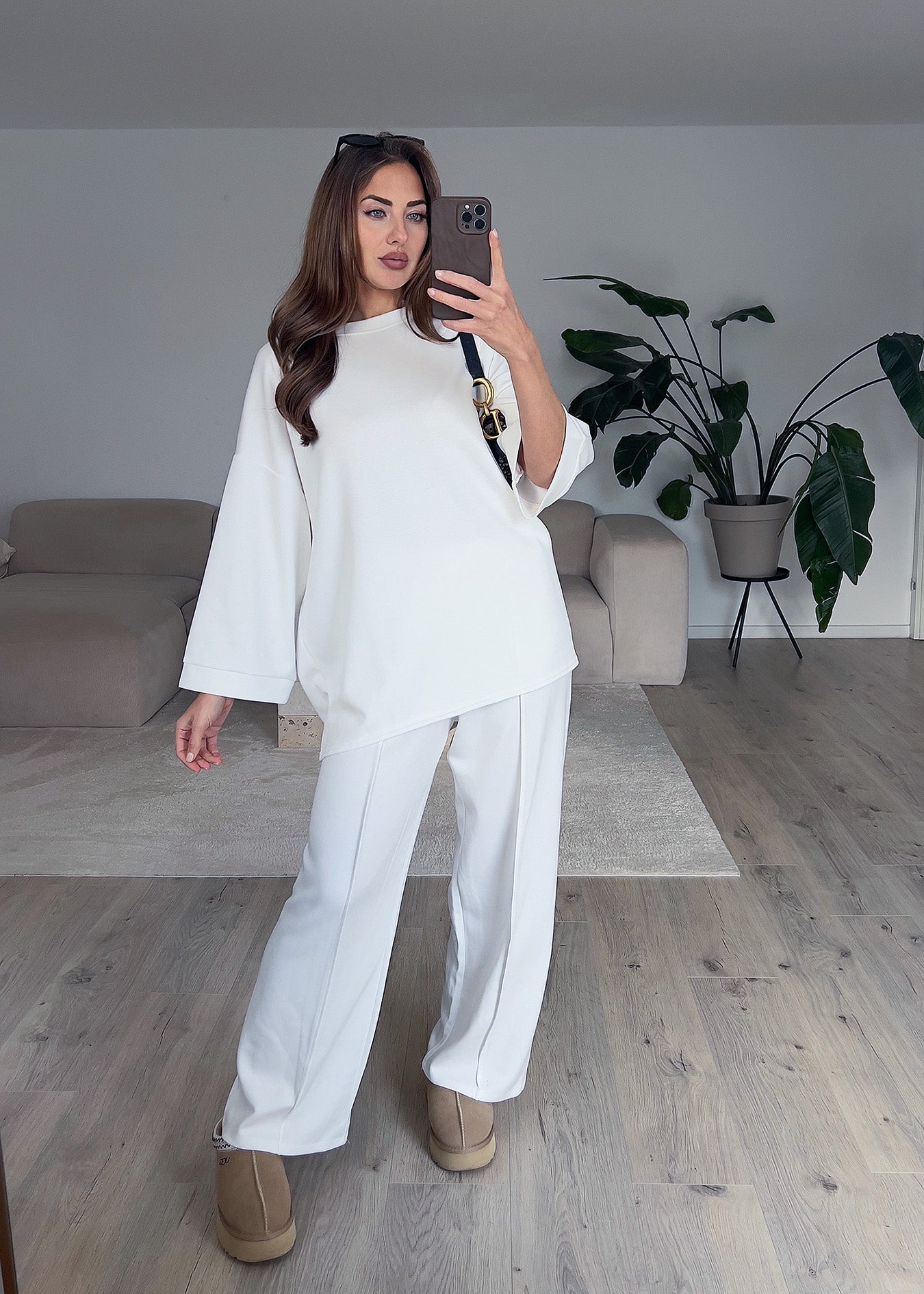 Modell trägt einen weißen Oversize Zweiteiler mit weitem Oberteil und lockerer Hose – perfekter Look für Komfort und Stil
