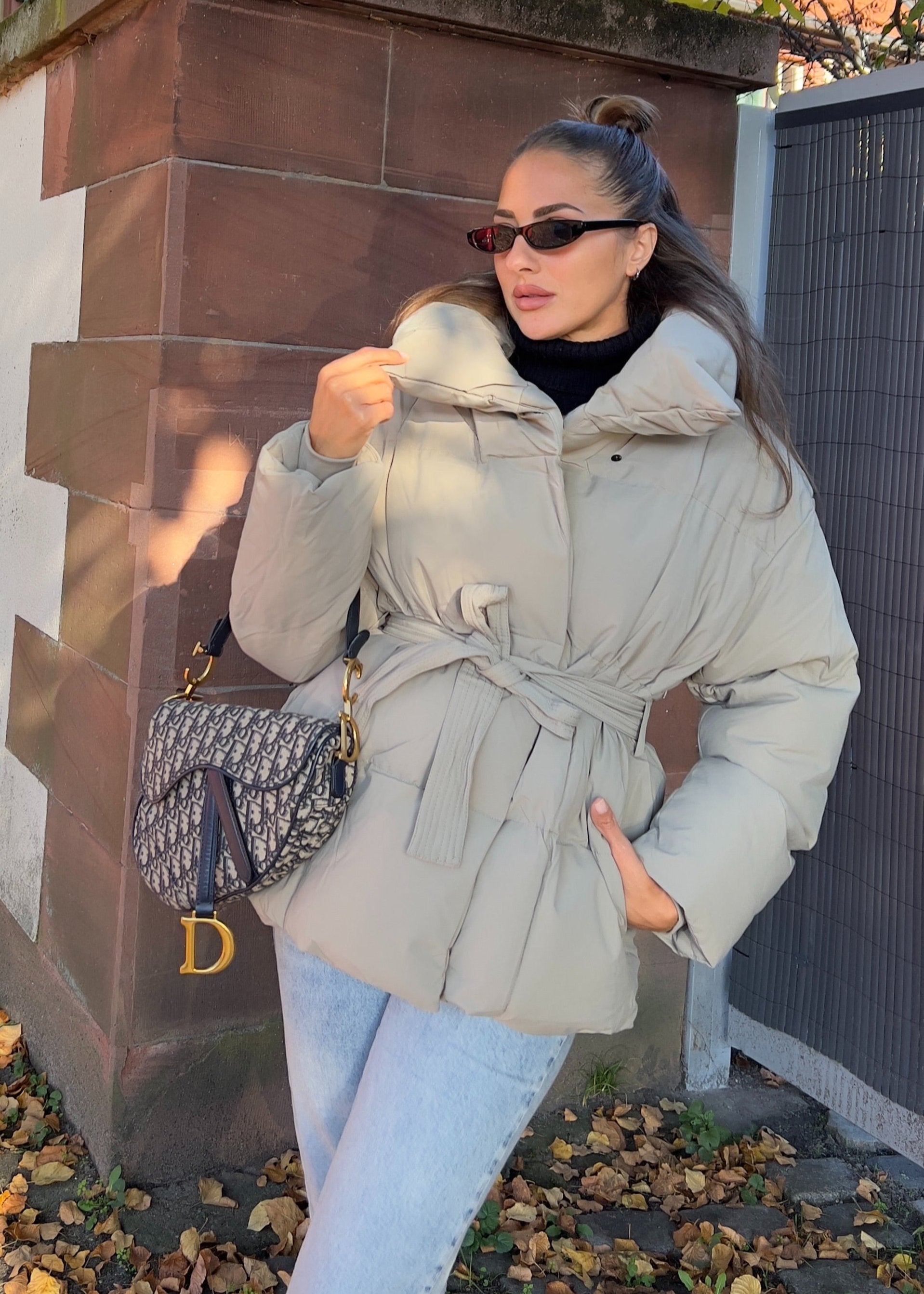 Modell trägt eine kurze Damen Steppjacke mit Taillengürtel – NAHA Fashion 