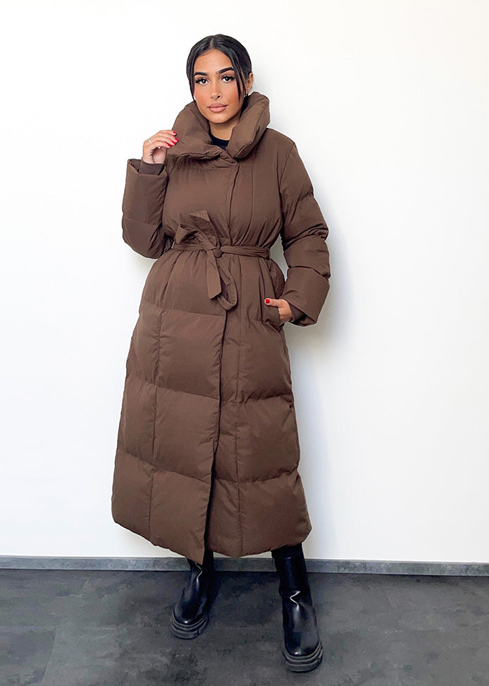 Frau trägt braune Winterjacke mit Gürtel & Stehkragen – gesteppt & warm von NAHA  