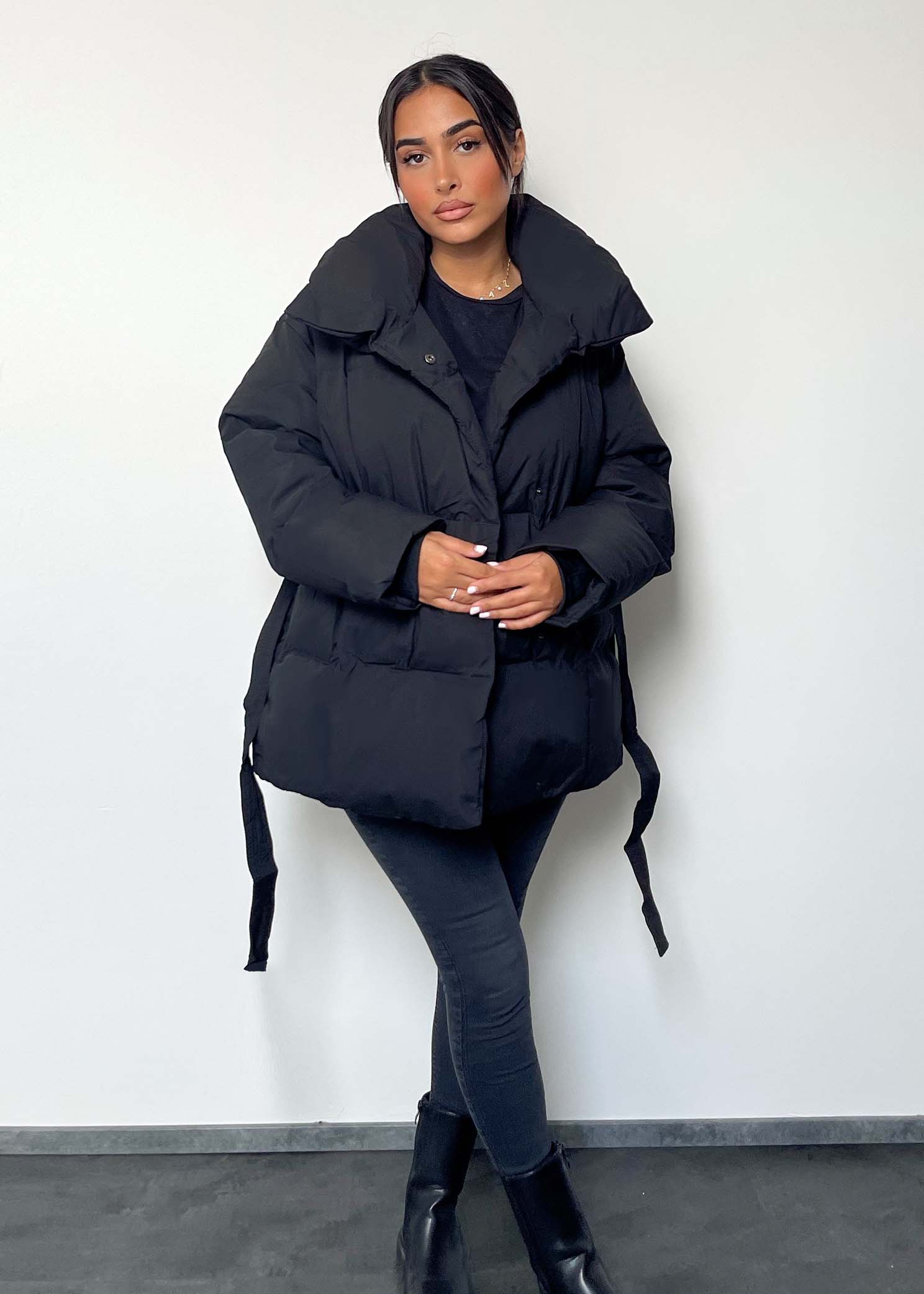 Modell trägt eine kurze Damen Steppjacke mit Taillengürtel – NAHA Fashion  